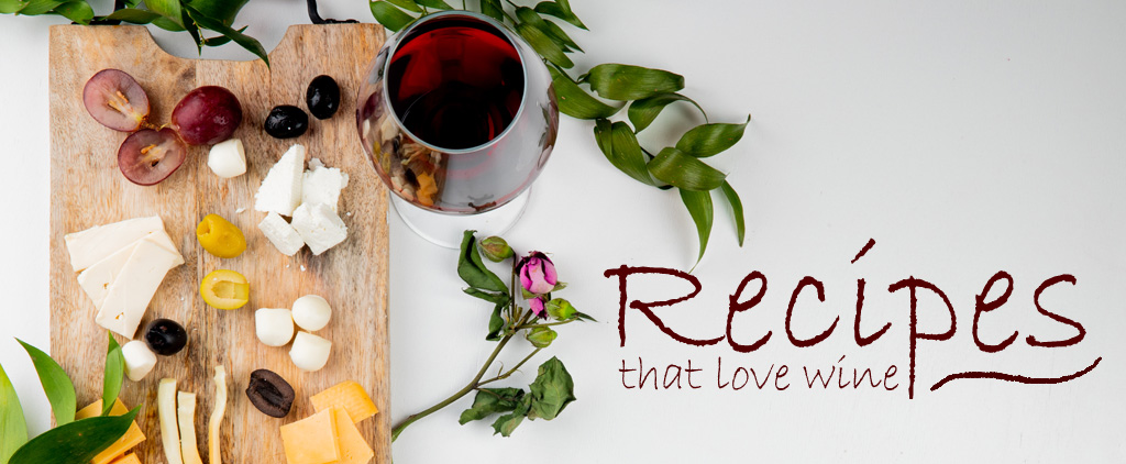 wine glass filled with red wine next to a cheese board and the words "Recipes that love wine"